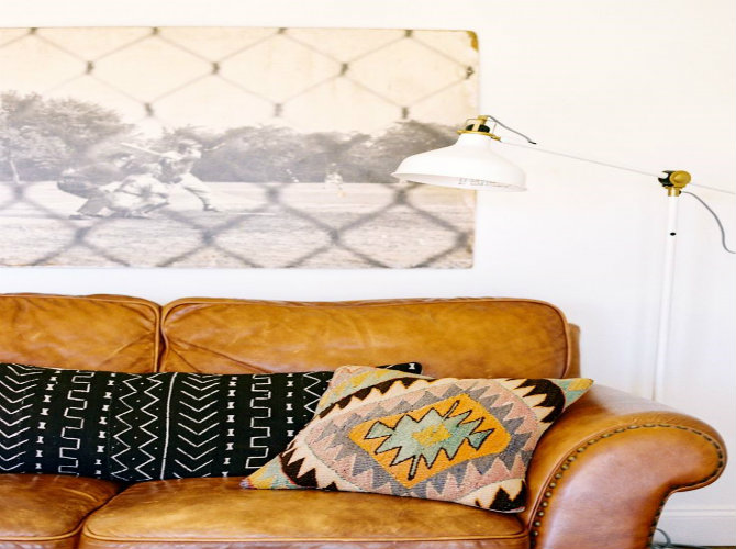 20 midcentury modern floorlamps Black and white art above leather sofa, patterned pillows, and modern floor lamp