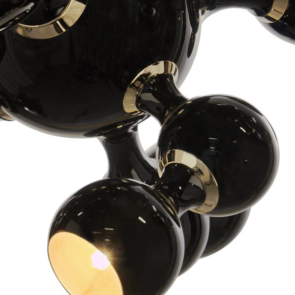 With a set of spotlights all arranged much similar to molecular forms. An exquisite gold-plated finish on the body, while the shades are lacquered a glossy black on the outside and a gold powder paint on the inside. It can be used as a suspension lamp in a modern entryway, and it also works beautifully as a bedroom ceiling lamp, especially in kids’ bedrooms.
