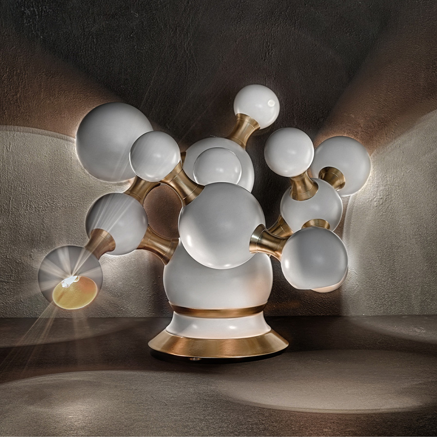 Atomic mid-century desk lamp was inspired by the molecular composition of the atom. With a body handmade in brass and steel, this large table lamp features a set of 4 round spotlights all arranged in an abstract organic composition. Weighing in at almost 20 pounds, Atomic table light has several gold-plated elements that turn it into a sophisticated option perfect for a modern home office, or a contemporary living room.