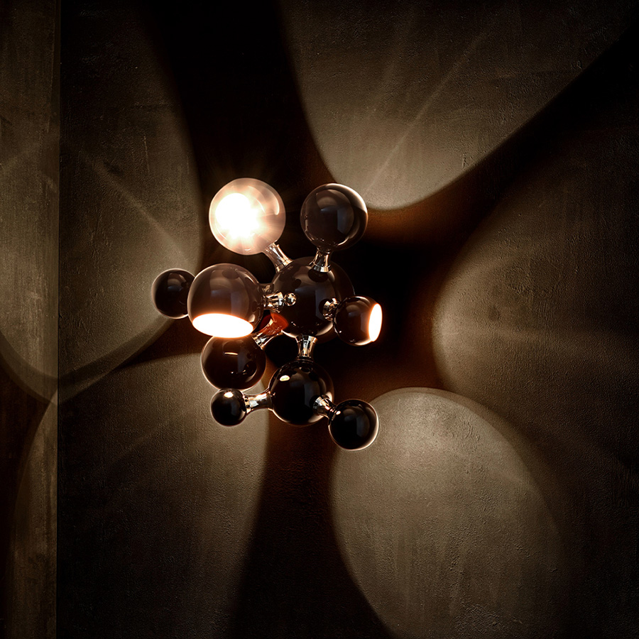 Atomic wall light is a mid-century modern lighting design inspired by the atomic discoveries of the mid-20th century. With multiple round shades that resemble the molecular composition of the atom, this interior wall light can give a fun twist to a contemporary home decor. Its body is handmade in brass and steel, with both a glossy black and a gold-plated finish.