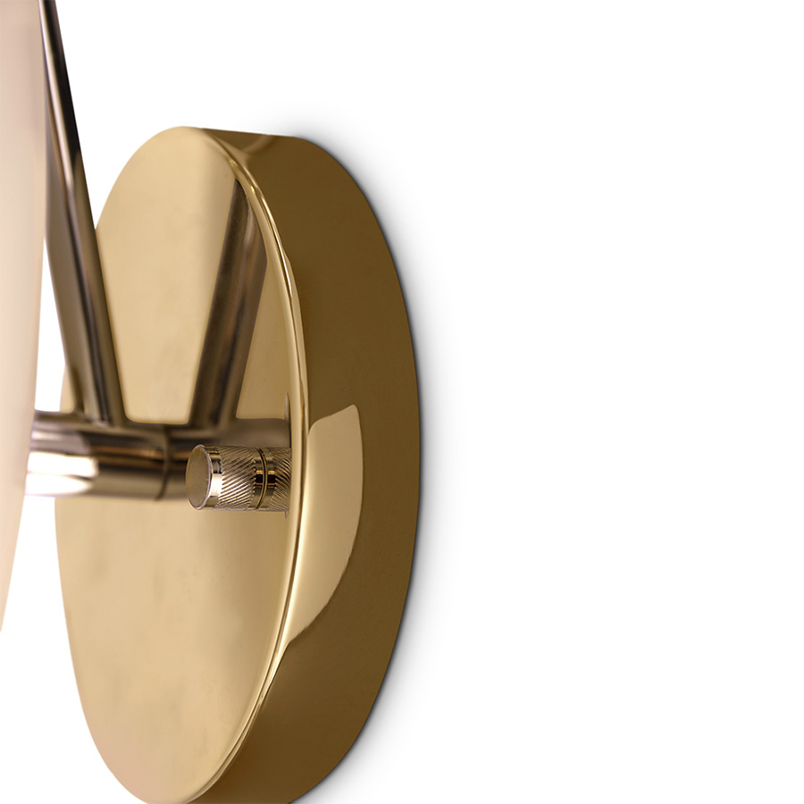 Basie wall light fixture is a modern representation of the sci-fi aesthetics of the 1960s. The vintage mid-century lamp has a set of distinctive features which make it a stunning statement piece. It is an indoor wall light handmade in brass, with a center shade made in Aluminium and a mesmerizing gold-plated standard finish. The lamp shade is lacquered a glossy white for a more modern look.