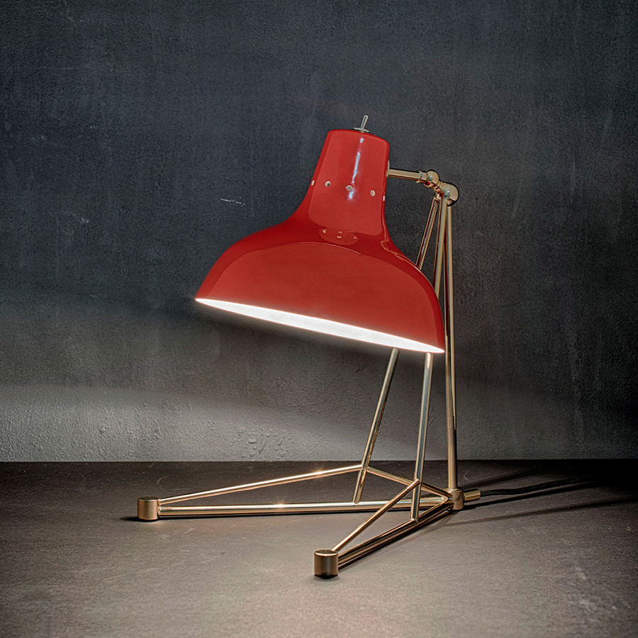 It is a handmade lamp built with materials such as brass and Aluminium. Brass was used on the body, whilst Aluminium was chosen for the shade. The Aluminium shade is lacquered a glossy red on the outside and matte white on the inside, while for the body a nickel-plated finish was chosen. However, both these colors and finishes can be customized according to your needs. having a movable and adjustable shade, that casts light to where it is needed.