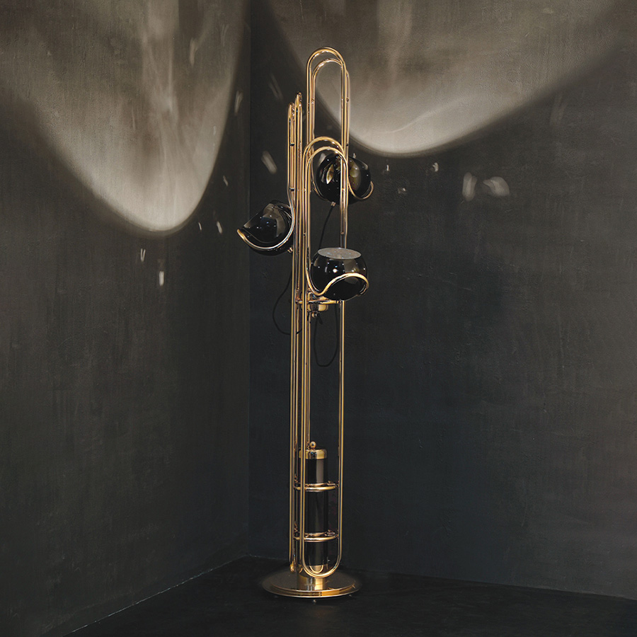 Neil floor lamp is a reminiscent lamp of the golden years of space. Around, brass base secures a black matte stem reaching up into three glossy black finished lampshades with a futuristic style. The three arms with flexible lights provide a good peripheric light range. The elegance of the continuous flowing center tubes gives a floating sensation to the whole piece, that would be perfect in a retro style living room next to a lounge chair or in a luxurious lobby.